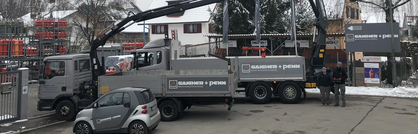 Kranwagen mit Gaigher + Penn-Beschriftung auf dem Hof